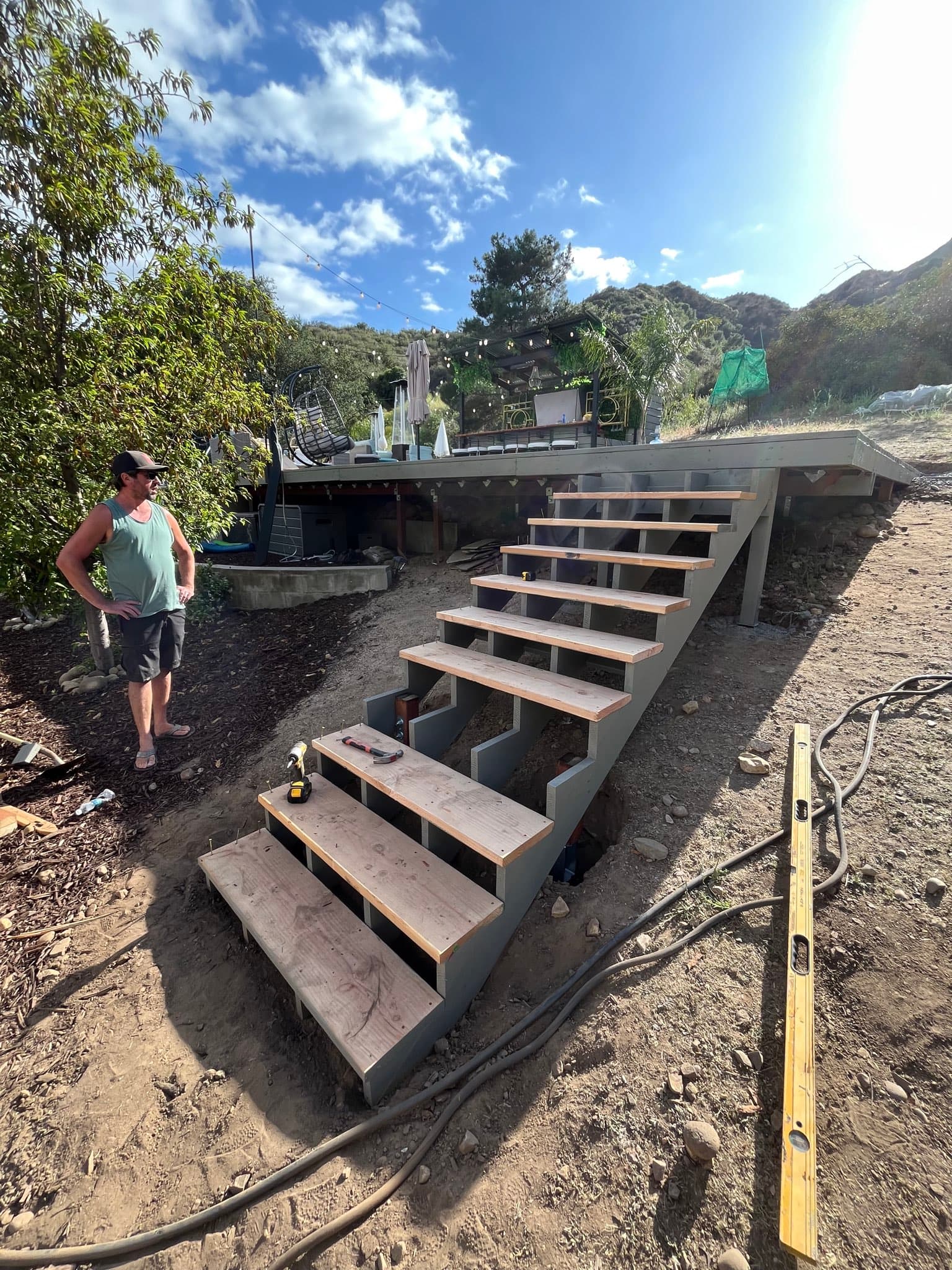 Deck stairs under construction on a hillside property