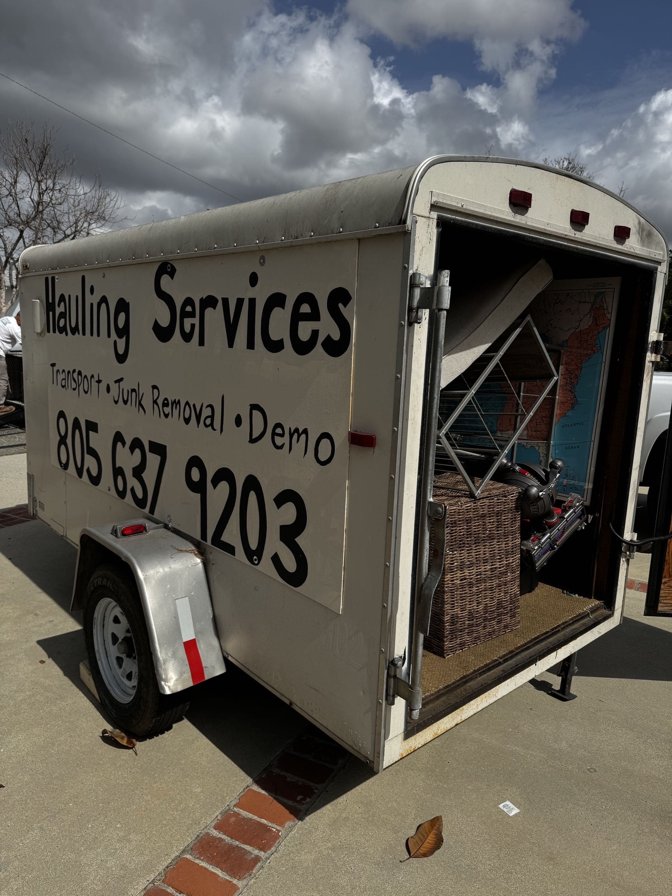 Open enclosed trailer loaded with household items for transport or hauling