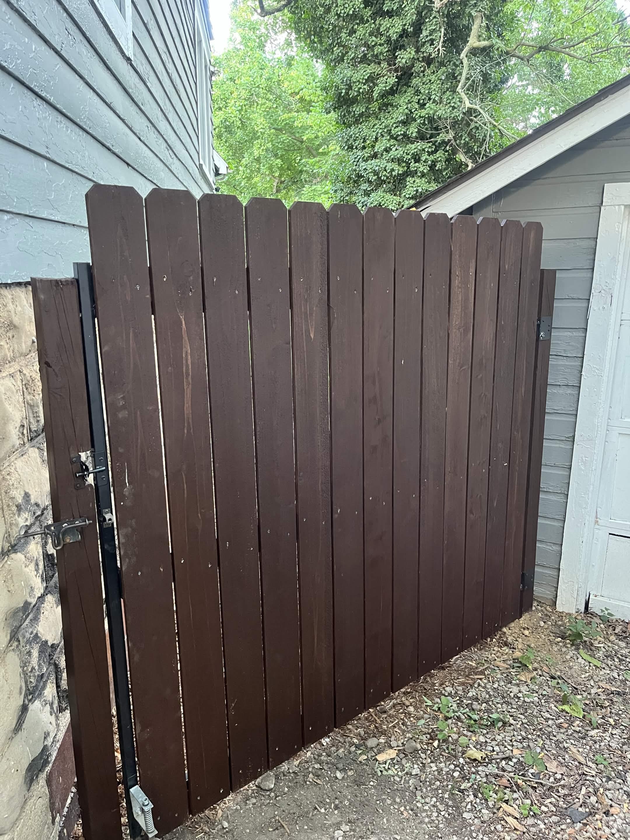 New dark wood side-yard gate after replacement work was completed